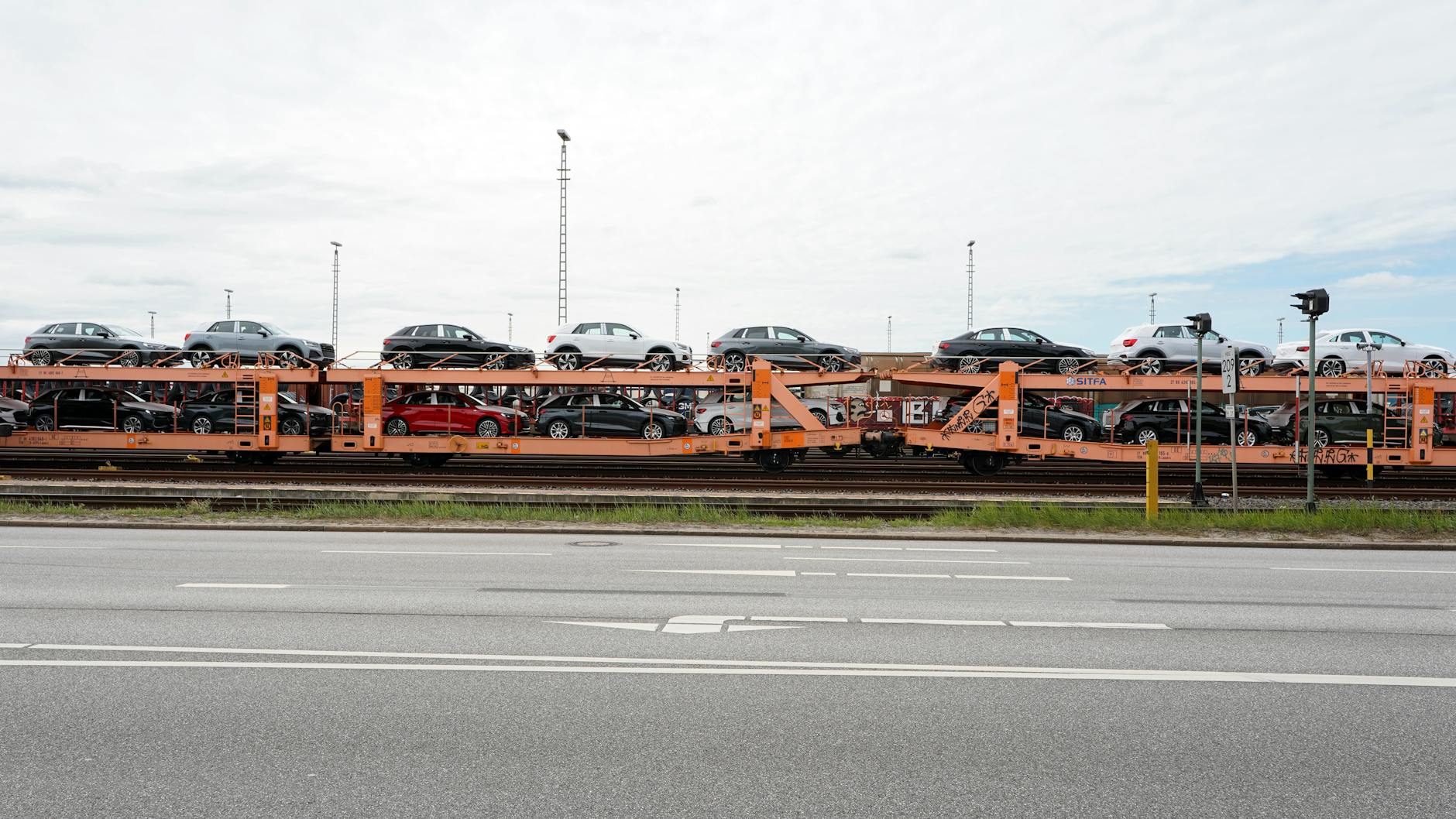 Automobiles on a transport train in Hamburg port area showcasing railway infrastructure.