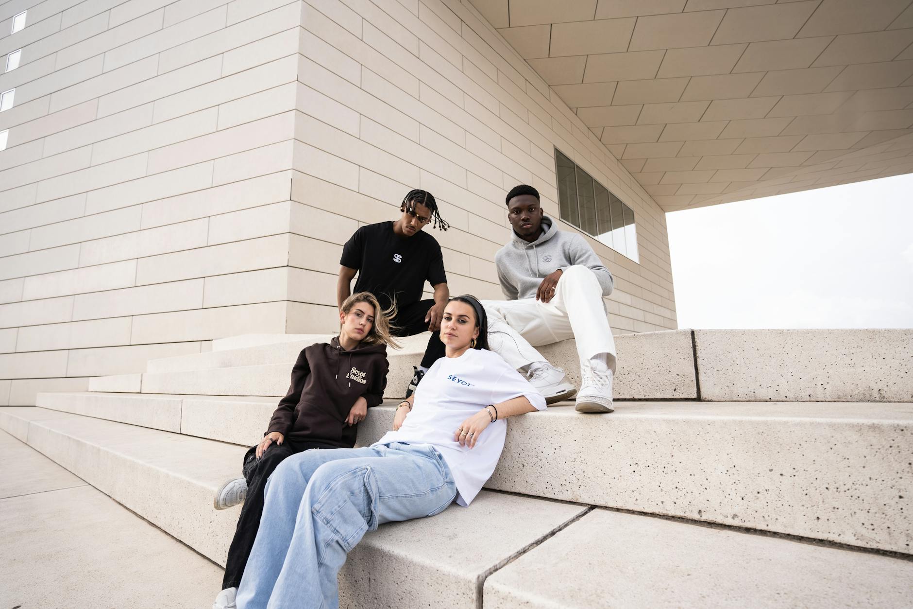 Urban group fashion portrait on steps of Bordeaux architecture.