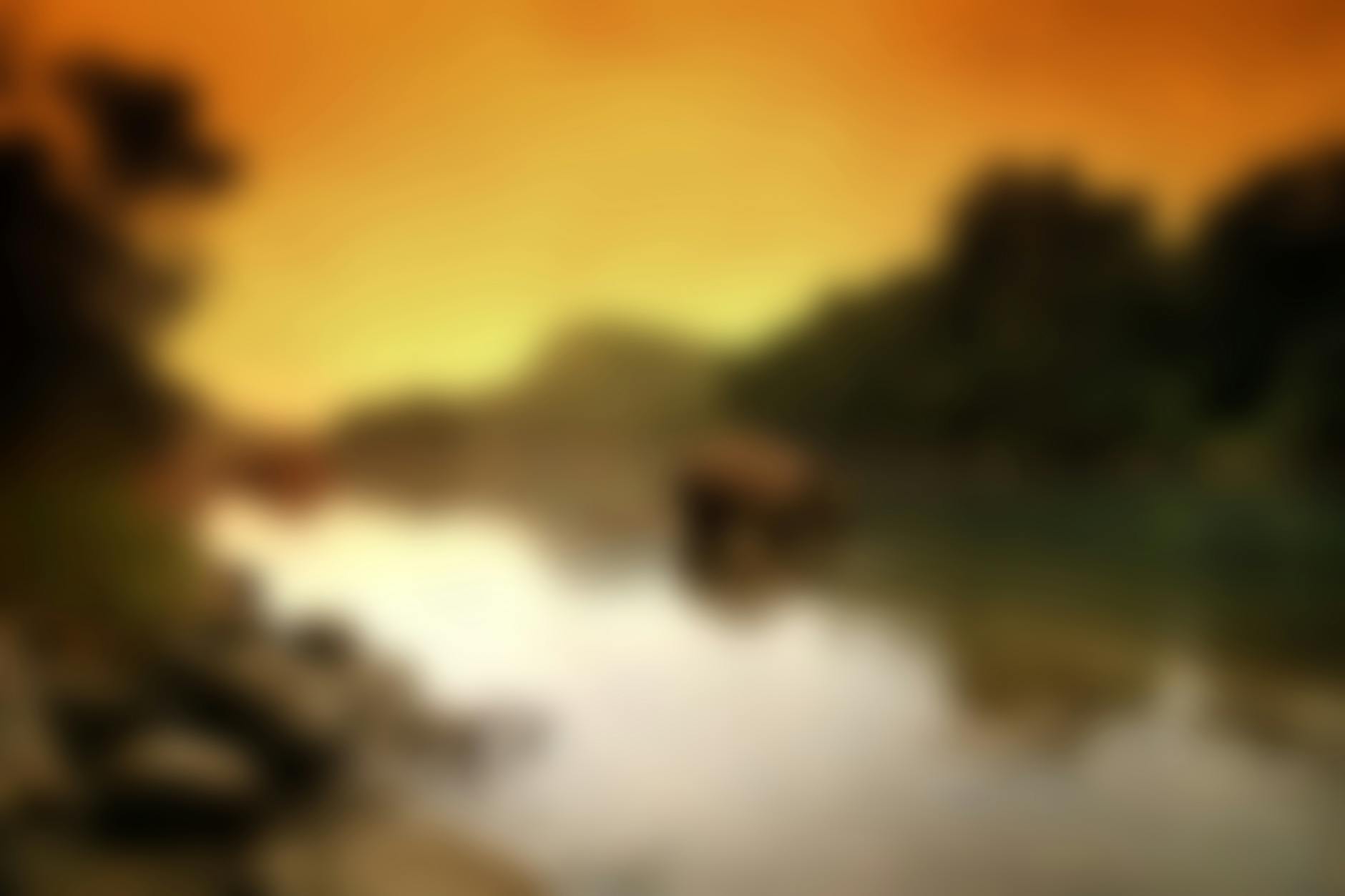 A beautiful blurred landscape depicting a serene sunset over water with trees.