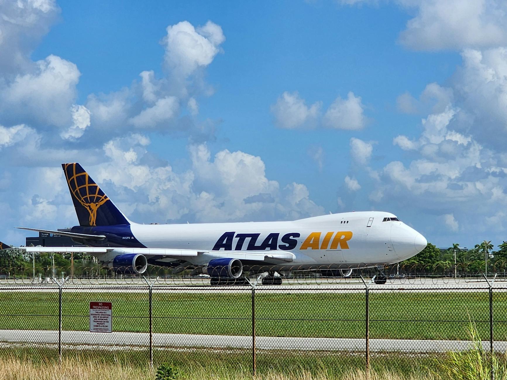 Atlas Air cargo plane taxiing on runway under a vibrant blue sky, captured outdoors.
